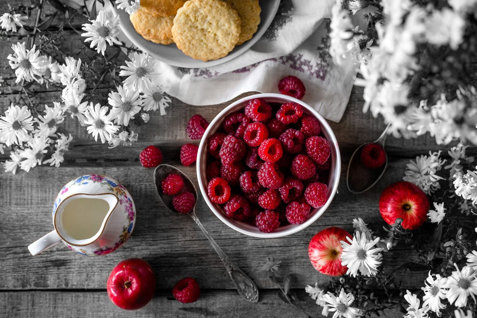 On the table Some berries, few apples and snacks are placed